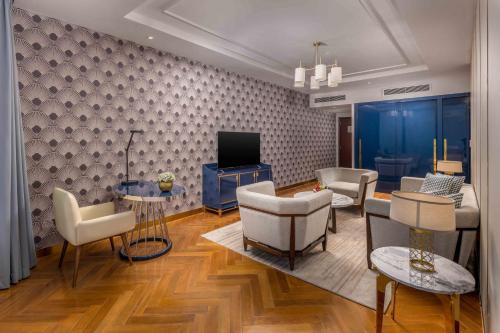 a living room with chairs and a tv and a couch at Vinpearl Ha Tinh, Affiliated by Melia in Ha Tinh