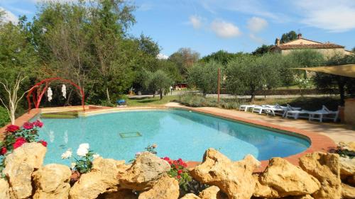 duży basen na dziedzińcu z kamienną ścianą w obiekcie San Martin del Colle Holiday Home w mieście Casciana Terme