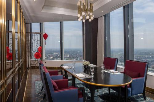 a dining room with a table and chairs and windows at Vinpearl Ha Tinh, Affiliated by Melia in Ha Tinh