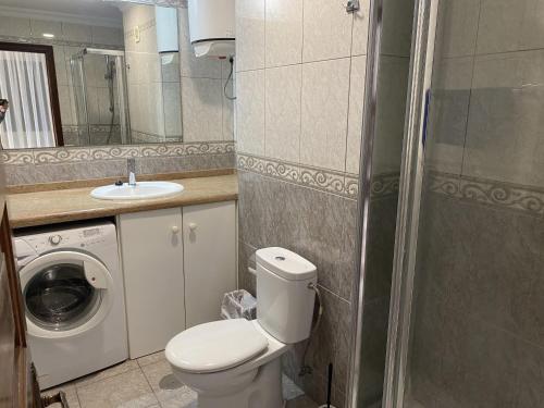 a bathroom with a toilet and a sink and a washing machine at Victoria Court Apartment 13A2 in Arona