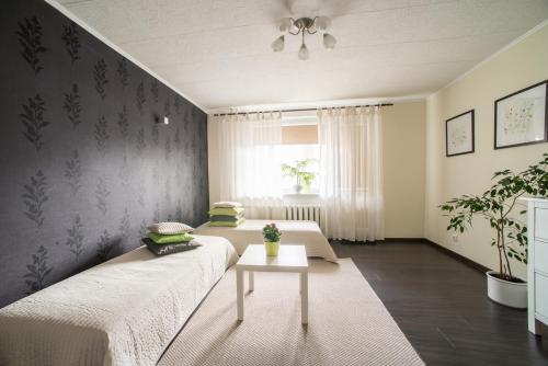 a living room with two beds and a table at Apartment Stay In in Druskininkai