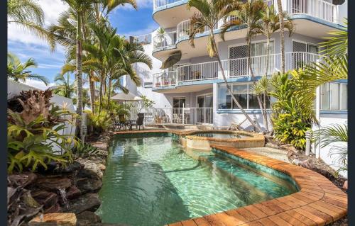 a swimming pool in front of a building at Coolum Sands Beachside Apartment in Coolum Beach