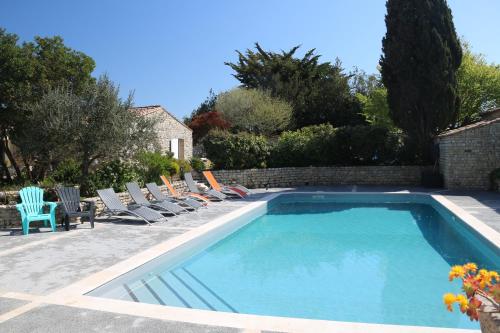 a swimming pool with lounge chairs next to a house at Villa del Ré 6 in La Flotte