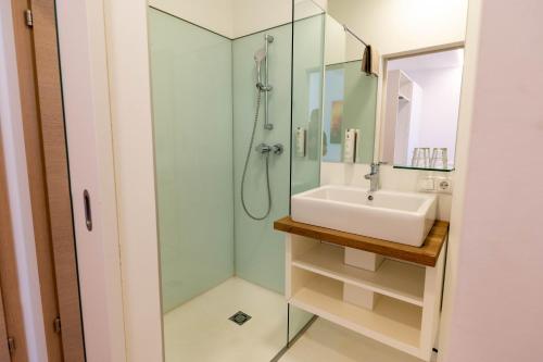 a bathroom with a sink and a shower at sHome Hotel Graz - Self-Check-in in Graz