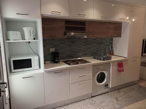 a kitchen with a microwave and a washing machine at Marsa BiBi in La Marsa