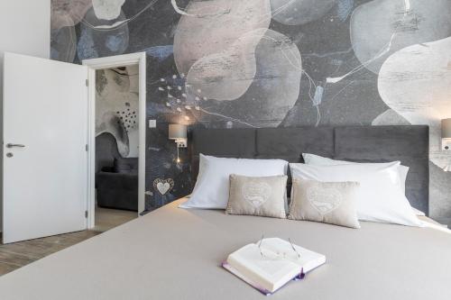 Un dormitorio con una cama con un libro. en Apartments & Rooms Kolovare Beach en Zadar
