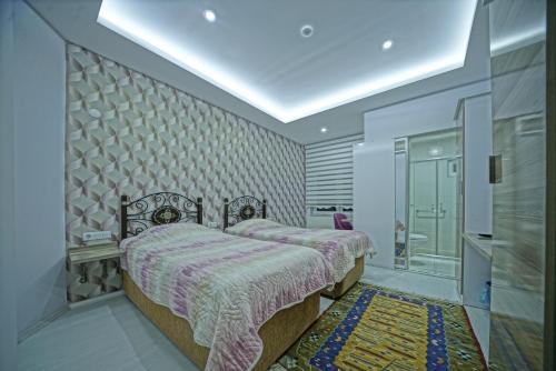a bedroom with two beds and a rug at Cappadocia Symbol Hotel in Uçhisar