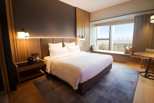a bedroom with a large bed and a large window at Pullman Dali in Dali