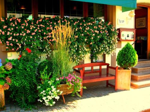 un banco rojo sentado frente a un edificio con flores en Hotel Restaurant Krone, en Wolfach