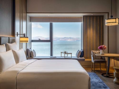 a bedroom with a large bed and a large window at Pullman Dali in Dali