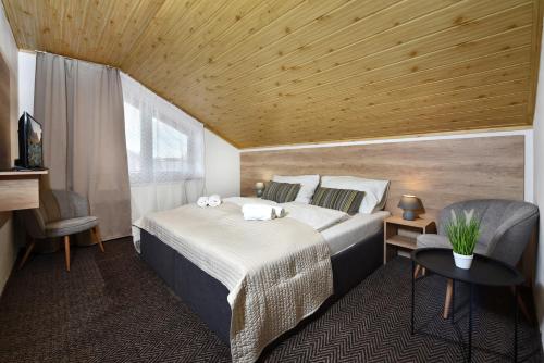a bedroom with a large bed and a wooden ceiling at Vila Martina in Poprad