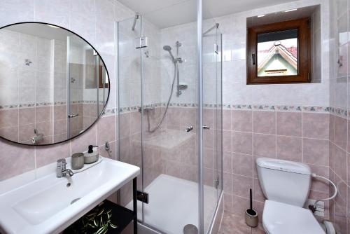 a bathroom with a shower and a toilet and a sink at Vila Martina in Poprad