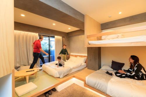 a room with two beds and two people in it at Sakura Cross Hotel Ueno Iriya Annex in Tokyo