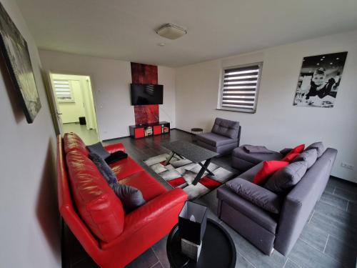 a living room with a red leather couch and chairs at Ferienwohnung-Irxleben in Irxleben