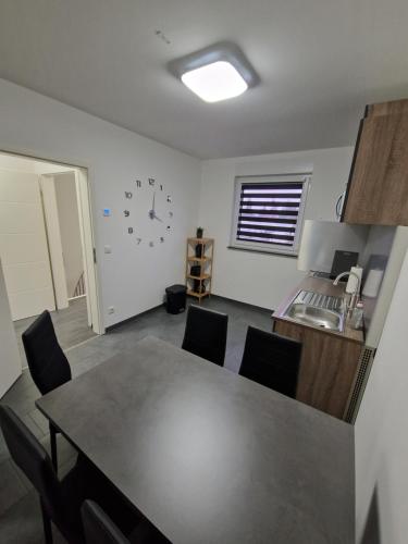 a dining room with a table and a clock on the wall at Ferienwohnung-Irxleben in Irxleben