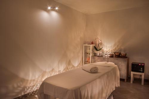 a bedroom with a bed and a white wall at Cala Sinzias Resort in Castiadas