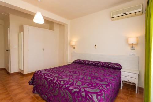a bedroom with a purple bed in a room at Hostal Sol y Miel in Benalmádena