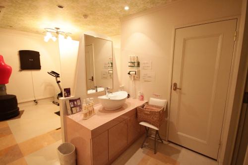 een badkamer met een wastafel en een grote spiegel bij ホテルアンの家 in Ikaho