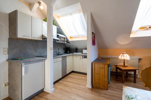 a small kitchen with white cabinets and a table at Almsonne in Bad Hindelang