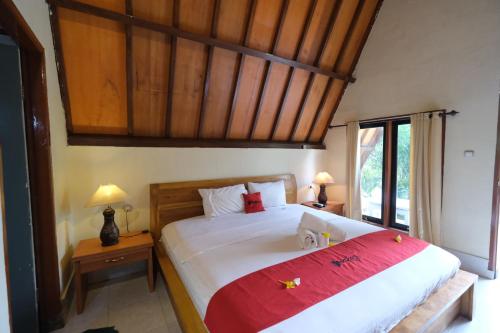 een slaapkamer met een groot bed en een rode deken bij RedDoorz at Ocean 2 Gili Trawangan in Gili Trawangan