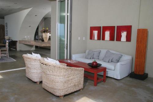a living room with a couch and chairs and a table at Mosselberg on Grotto Beach in Hermanus