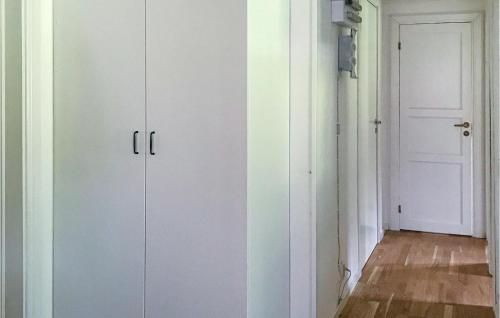 une paire de placards blancs dans une pièce avec porte dans l'établissement Lovely Home In Trngsviken With Kitchen, à TrÃ¥ngsviken