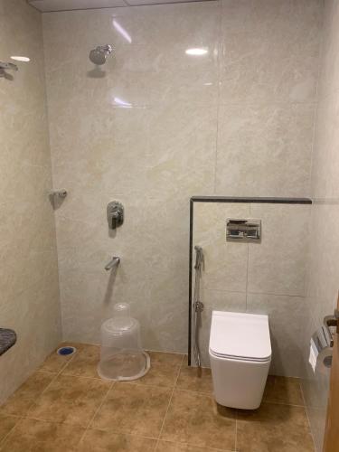 a bathroom with a shower with a toilet and a sink at JN Guestline in Devanahalli-Bangalore