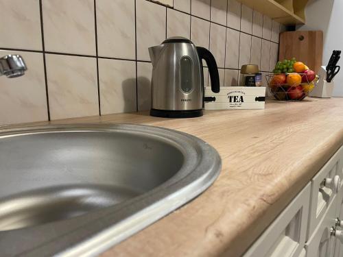 eine Küchentheke mit einer Spüle und einem Wasserkocher in der Unterkunft Apartament czteroosobowy z tarasem in Warschau