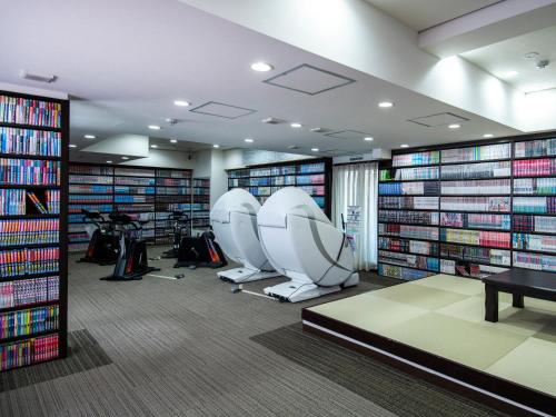a library with two chairs and a lot of books at Niigata Daiichi Hotel in Niigata