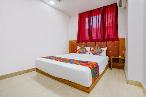 a bedroom with a large bed with a red curtain at FabExpress Diamond I in Mumbai