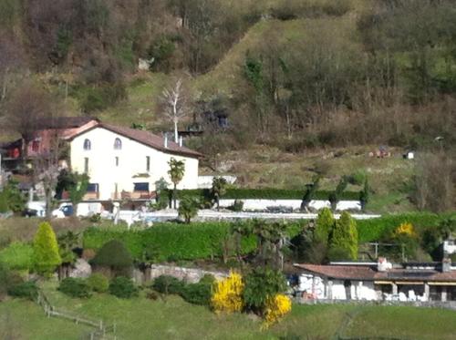 a large white house in the middle of a field at Casa Bellavista in Pugerna