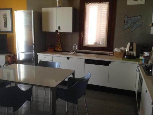 a kitchen with a table and a refrigerator at B&B Al Teatro in Comiso