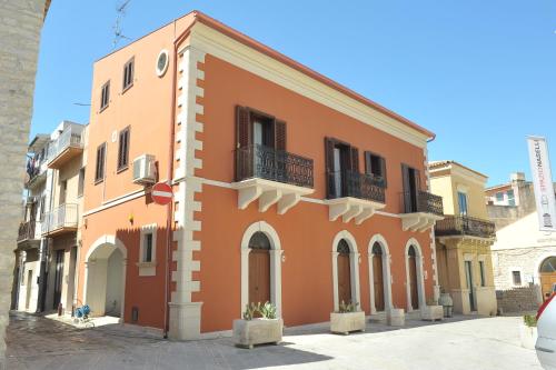 a orange building with a balcony on a street at B&B Al Teatro in Comiso