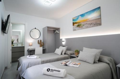 a hotel room with two beds and a mirror at Stay Belonio in Málaga