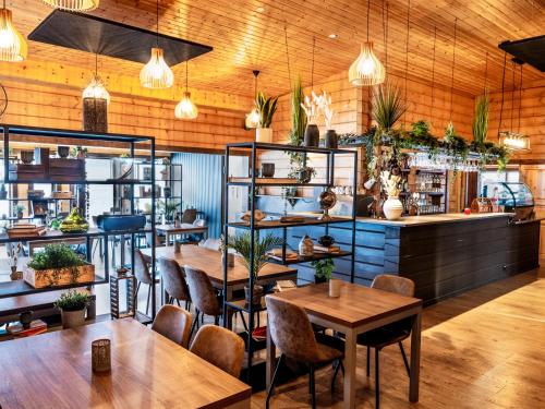 um restaurante com mesas, cadeiras e plantas em Lighthouse-Inn em Gardur