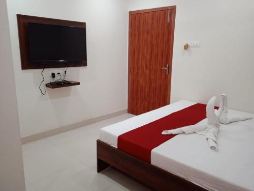 a bedroom with a bed with a television on the wall at HOTEL HAREN GRAND in Guwahati