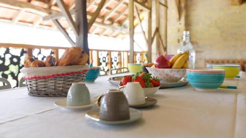 a table with bowls of food and fruit on it at Le Cabanot in Peyrusse-Grande