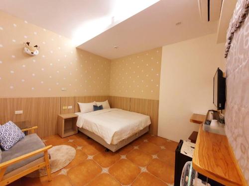 a bedroom with a bed and a tv in it at Warm & Cozy Inn in Hengchun