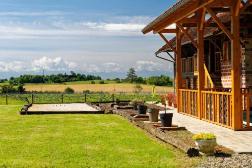 a wooden pavilion with a garden and a field at Le Cabanot in Peyrusse-Grande