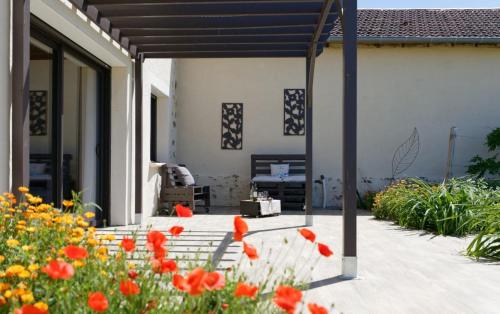 a patio with red poppies in a garden at Le Cabanot in Peyrusse-Grande