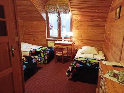a room with two beds and a table and a window at Malibu Lublin in Lublin