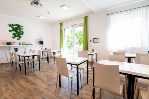 ein Esszimmer mit Tischen, Stühlen und einem Fenster in der Unterkunft sHome Hotel Graz - Self-Check-in & free parking in Graz