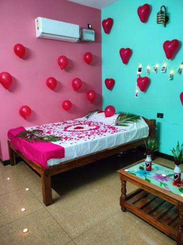 a bedroom with a bed with hearts on the wall at Paradise Forest Resort in Puducherry