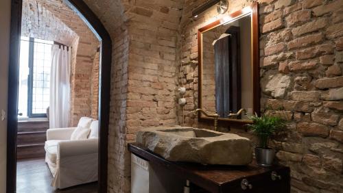 ein Badezimmer mit einem Steinwaschbecken in einer Ziegelwand in der Unterkunft "Casa del Pincetto" Centro storico in Perugia