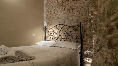 Bett in einem Zimmer mit Ziegelwand in der Unterkunft "Casa del Pincetto" Centro storico in Perugia