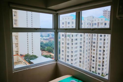 a window with views of a city from a building at Gilmore Tower Suites By SMS Hospitality in Quezon City
