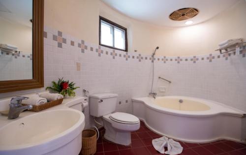 a white bathroom with a tub and a toilet and a bath tub at Imperial Phukaew Hill Resort in Khao Kho