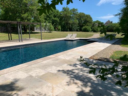 una piscina con 2 sillas en un patio en cabane lodge avec spa privatif, en Livernon