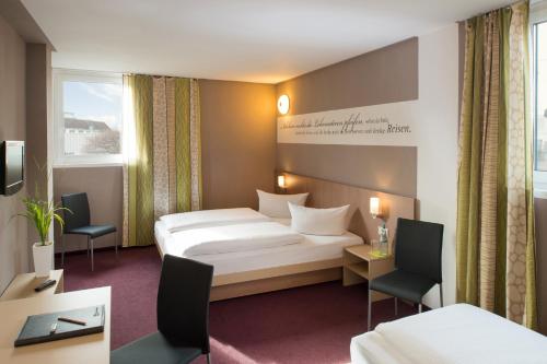 a hotel room with a large bed and a television at Hotel Mainstation in Frankfurt