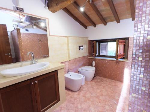 y baño con lavabo y aseo. en Casa privata immersa nel verde con giardino e piscina, ad Assisi, en Mora